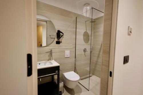 a bathroom with a shower and a toilet and a sink at Hotel Tutti in Durrës