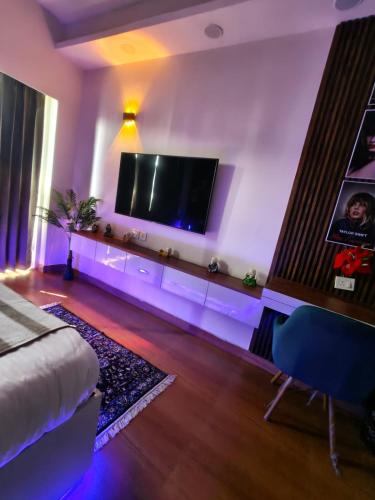 a living room with a flat screen tv on the wall at Caelume Luxury Studios in Ghaziabad