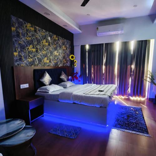 a bedroom with a large bed with a blue lighting at Caelume Luxury Studios in Ghaziabad