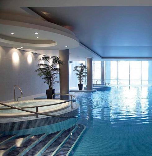 a large swimming pool in a building with plants at The River Lee Hotel a member of The Doyle Collection in Cork