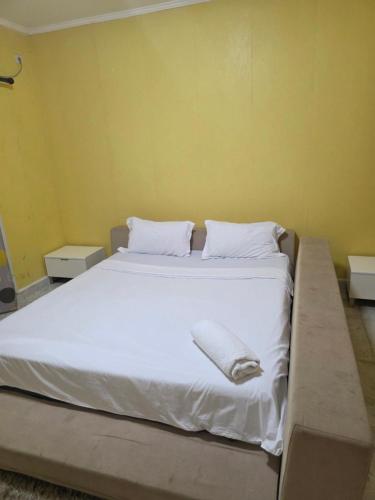 a bedroom with a bed with white sheets and pillows at N24 Confy apartment in Luanda