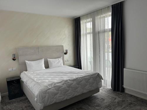 a bedroom with a bed and a large window at Atri's Boutique in Aiud