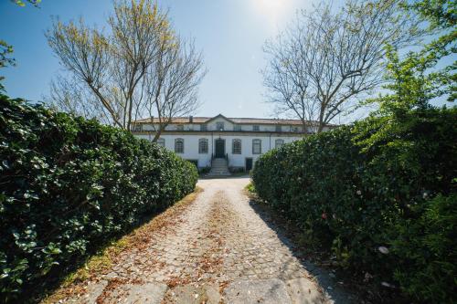 a white house with a dirt road in front of it at Casa de Cabanelas in Bustelo