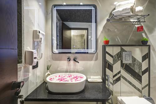 a bathroom with a large white sink with sprinkles at Hotel Stay Well Dx in New Delhi