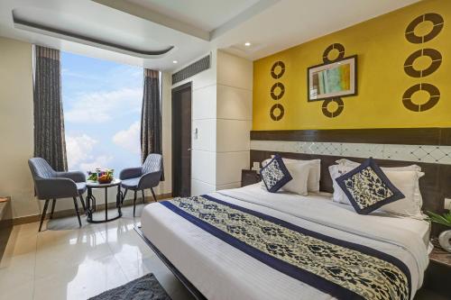 a bedroom with a bed and a table with chairs at Hotel Stay Well Dx in New Delhi