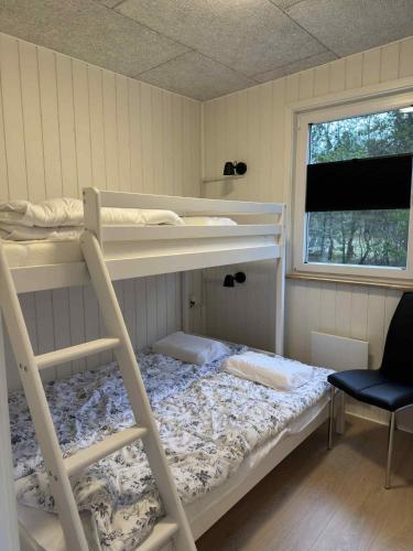a room with two bunk beds and a chair at Rødhus Camping in Pandrup