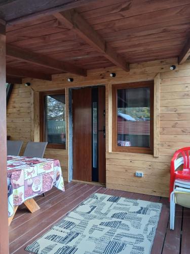 a wooden cabin with a bed and a glass door at Domek nad jeziorem in Jagodne