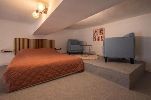 a bedroom with a bed and two chairs at La vie en rose in Grasse