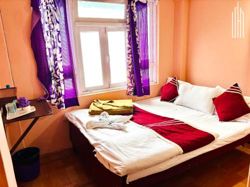 a small bed in a room with a window at PEMA Hotel VSTM in Darjeeling