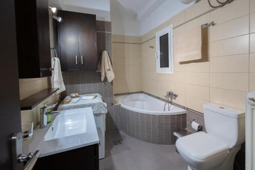 a bathroom with a tub and a toilet and a sink at Seaside Apartment with a great view in Chalkida in Chalkida