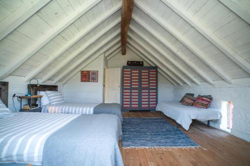 a attic room with two beds and a couch at Casa de Cabanelas in Bustelo