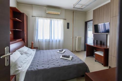 a bedroom with a bed and a desk and a television at Seaside Apartment with a great view in Chalkida in Chalkida