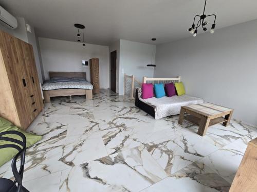 a room with a marble floor with two beds and a table at Apartament Sosnowy Las Widok na morze in Rowy