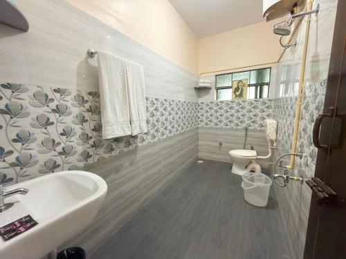 a bathroom with a sink and a toilet at Naadi Grand Inn in Thanjāvūr