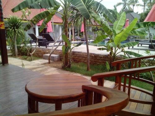 a wooden table and chairs on a balcony at Naradas Mushroom Beach in Nusa Lembongan