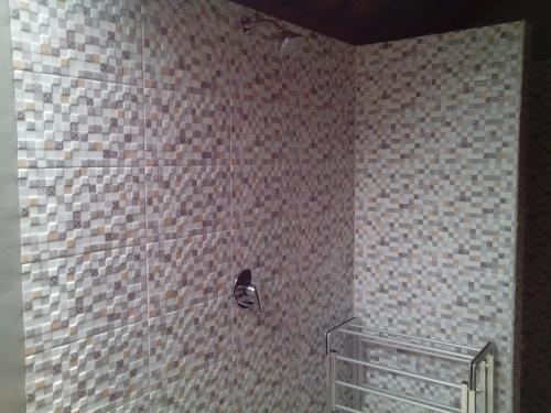 a bathroom with a tiled wall with a shower at Naradas Mushroom Beach in Nusa Lembongan