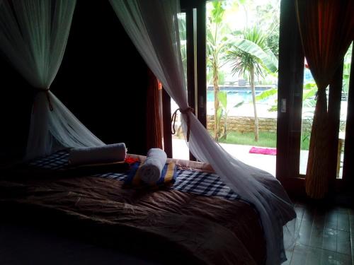 a bed with a hammock in a room with a window at Naradas Mushroom Beach in Nusa Lembongan