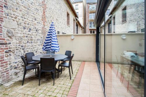 a table and chairs with a hat on a patio at Maison charmante près de Sainte Catherine in Honfleur