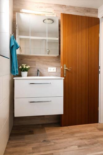 a bathroom with a sink and a wooden door at Landhaus Osttirol in Iselsberg
