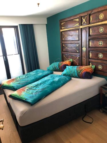 a bedroom with a bed with pillows and a dresser at Landhaus Osttirol in Iselsberg