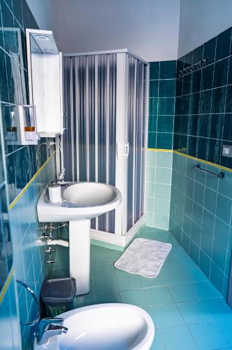 a blue tiled bathroom with a sink and a toilet at B&B dalla Nonna in Salerno