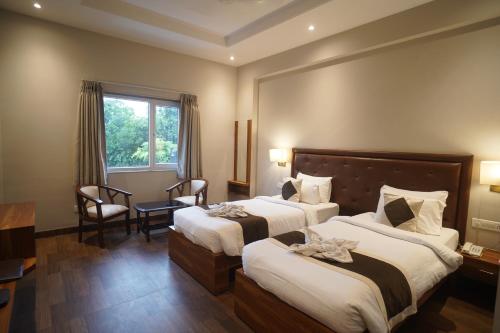 a hotel room with two beds and a window at Neel Clarks Inn Express in Agra