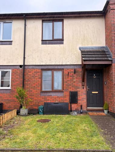 a brick house with a black door at Lovely Holiday Home to explore beautiful West Wales in Carmarthen