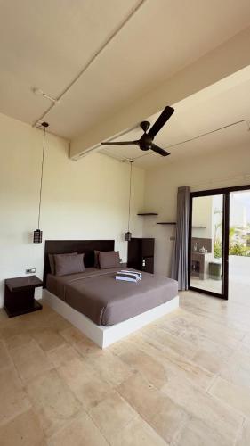 a bedroom with a bed and a ceiling fan at Tris Villa 3 in Bumbang