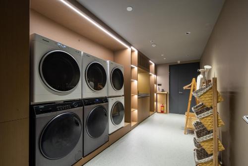 a laundry room with four washer and dryer machines at Atour Hotel Hefei Changjiang Road Zhixincheng Annongda in Hefei