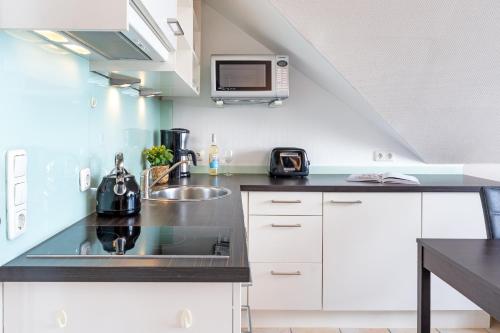 a kitchen with a sink and a microwave at Strandburg Ostseeblick Scharbeutz in Scharbeutz