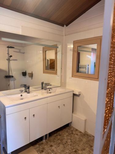 a bathroom with two sinks and a mirror at Au Pays de Cocagne in Nyons