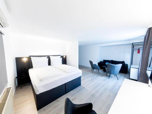a bedroom with a bed and a living room at DORMERO Hotel Aalen in Aalen