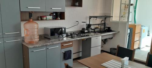 a kitchen with a counter with a microwave and a sink at DePA DRAGON in Tizayuca