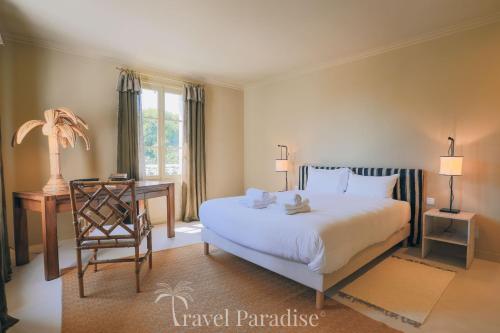 a bedroom with a bed and a table and a chair at Villa Phoenix in La Couarde-sur-Mer