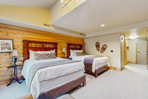 a large bedroom with two beds and wooden walls at Hotel studio with views fireplace & close to everything in Park City