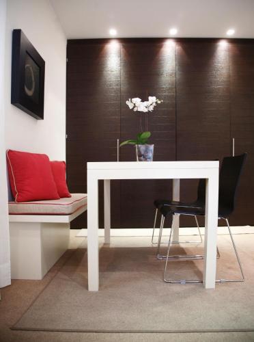 a white table and a chair with a plant on it at Residence Lungomare - Charming apartments in Riccione