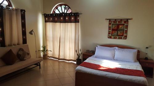 a bedroom with a bed and a couch at Grace Green Ville in Negombo