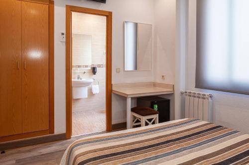 a bedroom with a bed and a sink and a bathroom at Hotel Mediodia in Madrid