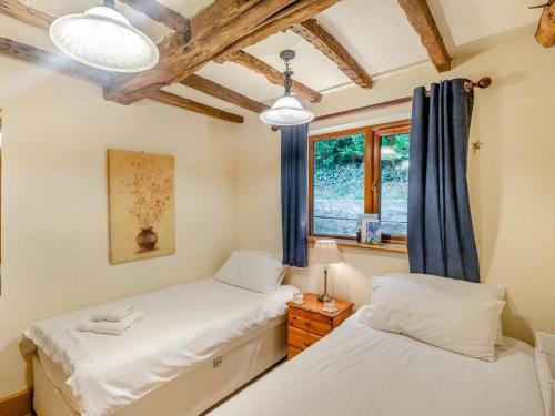 two twin beds in a room with a window at 3 Bed in Bridgnorth oc-thfis in Highley