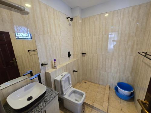a bathroom with a white toilet and a sink at Impala Villas in Mombasa
