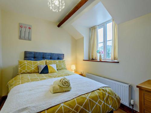a bedroom with a large bed with a yellow bedspread at 3 Bed in Builth Wells oc-52463 in Alltmawr