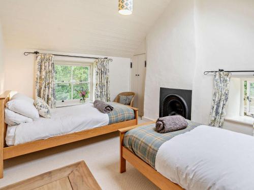 a bedroom with two beds and a fireplace at 2 Bed in Chepstow oc-42837 in Wolves Newton
