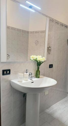 a bathroom sink with a vase of flowers on it at B&B La Casa di Olga in Bobbio