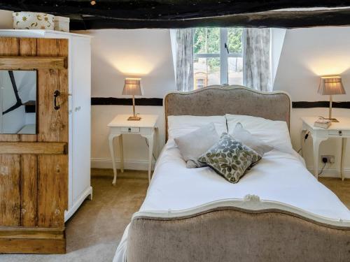 a bedroom with a white bed with two lamps and a mirror at 3 Bed in Stratford-upon-avon oc-95736 in Stratford-upon-Avon