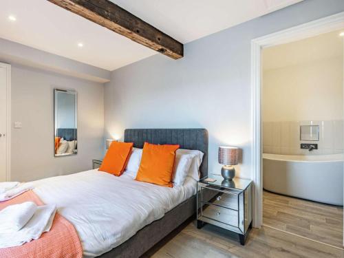 a bedroom with a bed with orange pillows at 4 Bed in Bideford oc-86776 in Appledore
