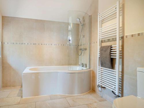 a bathroom with a white tub and a shower at 4 Bed in Brecon oc-bn182 in Talgarth