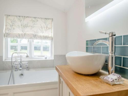 a bathroom with a sink and a bath tub at 1 Bed in Brecon oc-88748 in Aber-Brân