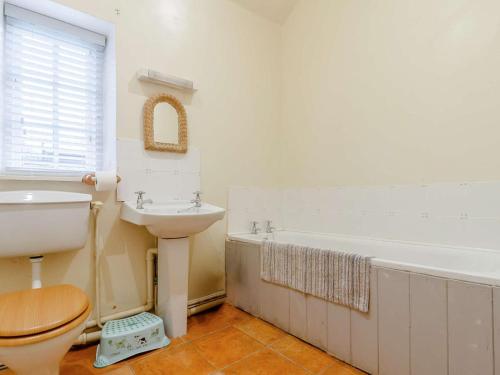 a bathroom with a toilet and a sink and a tub at 3 Bed in Abergavenny oc-90233 in Llanvetherine