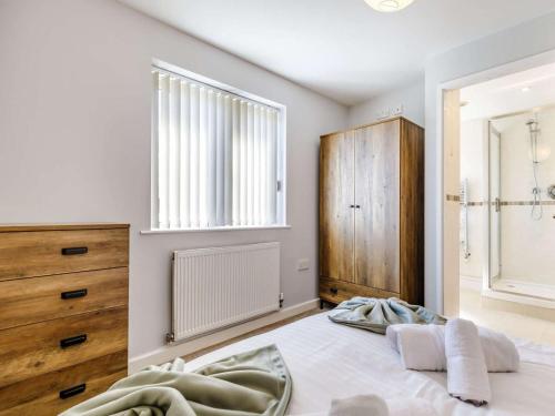 a bedroom with a bed and a dresser and a window at 5 Bed in Matlock oc-88486 in Crich