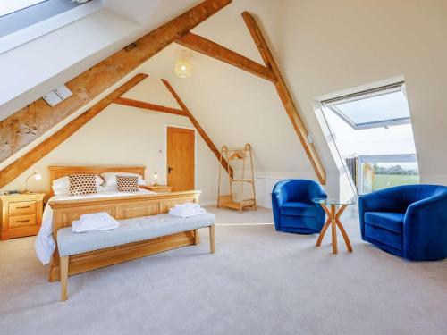 a bedroom with a bed and two blue chairs at 1 Bed in Faringdon oc-88573 in Coxwell